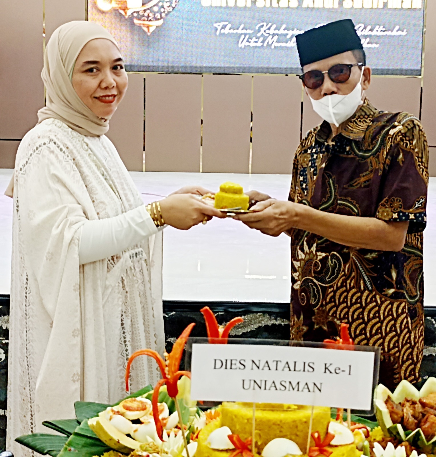 Andi Harni, S.ST Ibu Ketua Yayasan Andi Sudirman menyerahkan potongan Nasi Tumpeng Dies Natalis Pert